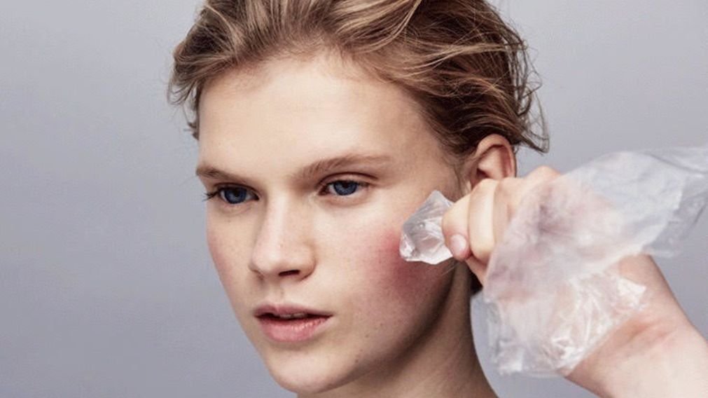 Paciente aplicando compressa de gelo na face após implante dentário para reduzir inchaço e dor